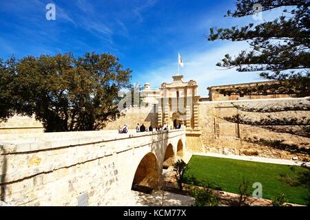 Touristen überqueren Sie die Fußgängerbrücke zum Stadttor und Stadtzentrum, Mdina, Malta, Europa. Stockfoto