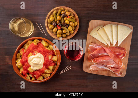 Tapas und Wein. Patatas Bravas, Oliven, Schinken, Käse Stockfoto