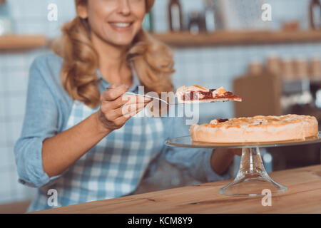 Kellnerin mit Kuchen im Cafe Stockfoto