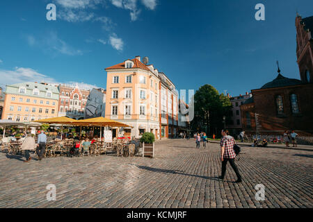 Riga, Lettland - 1. Juli 2016: Menschen in Street Café Restaurant in der Altstadt ruhen unter Fassaden der alten architektonischen Gebäuden in der Nähe von Domplatz im Sun Stockfoto