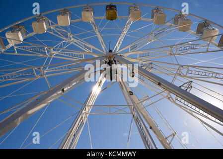 Eine weiße Riesenrad mit Kabinen von unten gegen den blauen Himmel gesehen Stockfoto