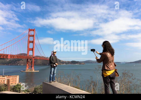 San Francisco, Kalifornien, USA - 15. September 2017: eine asiatische Frau nimmt ein Foto von einem Mann mit Ihrem Mobile auf einem selfie Stick im Golden Gate Stockfoto