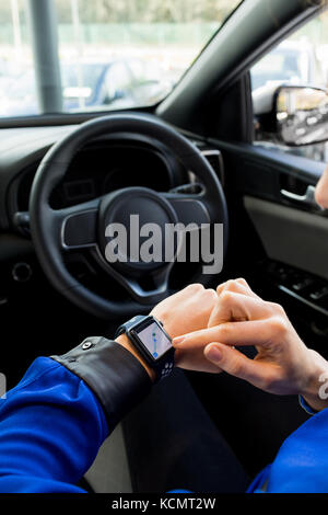 Hohe Betrachtungswinkel von Frau mit smart Watch im Auto während der Fahrt Stockfoto