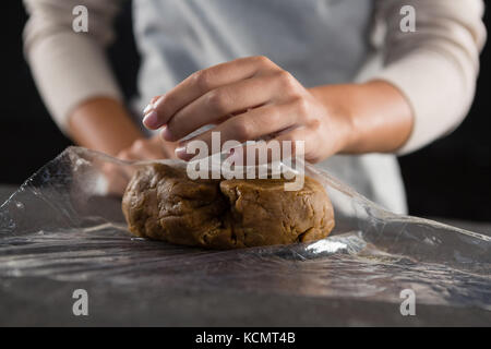 Den mittleren Abschnitt der Frau Verpackung Teig in einer Plastikverpackung Stockfoto