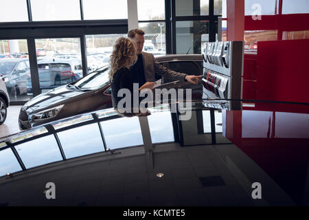 Verkäufer mit Farbmuster für weibliche Kunden beim Stehen in der Showroom Stockfoto