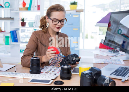 Weibliche Führungskraft Reparatur einer digitalen Kamera im Büro Stockfoto