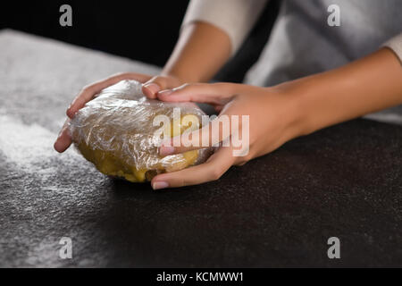 In der Nähe von Frau mit Teig mit Plastik in der Hand gewickelt Stockfoto