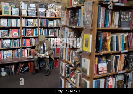 Umgeben von gebrauchten Büchern ist ein älterer Herr Lesung ein Titel, die die Regale der Second-hand Bookshop' Barter Books" in die northumbrian Stadt Alnwick, am 26. September 2017, in Alnwick, Northumberland, England. Stockfoto