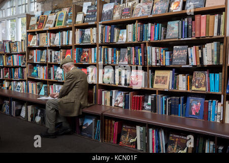 Umgeben von gebrauchten Büchern ist ein älterer Herr Lesung ein Titel, die die Regale der Second-hand Bookshop' Barter Books" in die northumbrian Stadt Alnwick, am 26. September 2017, in Alnwick, Northumberland, England. Stockfoto