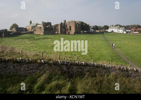 Die Landschaft rund um das Anfang des 12. Jahrhunderts Lindisfarne Priory auf der heiligen Insel, am 27. September 2017, auf Lindisfarne Insel, Northumberland, England. Das Kloster von Lindisfarne wurde von irischen Mönch St. Aidan gegründet, und das Kloster wurde vor Ende des 634 und Aidan gegründet, es blieb bis zu seinem Tod in 651. Die heilige Insel von Lindisfarne, auch einfach als Holy Island genannt, ist eine Insel vor der Nordostküste Englands. Heilige Insel hat einen aufgezeichneten Geschichte aus dem 6. Jahrhundert AD; es war ein wichtiges Zentrum des Keltischen und Anglo-sächsischen Christentums. Nach der Viking Invasionen und der N Stockfoto