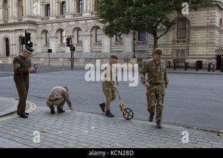 Laut Protokoll, Mitglieder der Coldstream Guards, durch "led-H. M. in der zeremoniellen Warrant Officer WO1 (GSM) Andrew "Vern" Stokes, Mark in der Kreide die Route entlang Whitehall für eine künftige Zeremonie, am 5. Oktober 2017, in London, England. Stockfoto