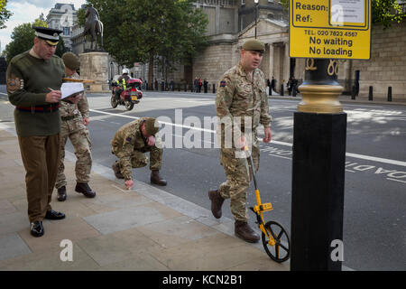 Laut Protokoll, Mitglieder der Coldstream Guards, durch "led-H. M. in der zeremoniellen Warrant Officer WO1 (GSM) Andrew "Vern" Stokes, Mark in der Kreide die Route entlang Whitehall für eine künftige Zeremonie, am 5. Oktober 2017, in London, England. Stockfoto