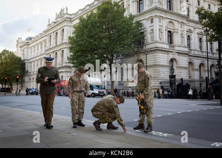 Laut Protokoll, Mitglieder der Coldstream Guards, durch "led-H. M. in der zeremoniellen Warrant Officer WO1 (GSM) Andrew "Vern" Stokes, Mark in der Kreide die Route entlang Whitehall für eine künftige Zeremonie, am 5. Oktober 2017, in London, England. Stockfoto