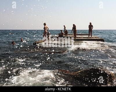 In Jalta auf der Krim - September 20, 2017: wellenbrecher mit Schwimmer und Sonnenanbeter Menschen Stockfoto