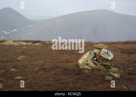 Ordentlich Cairn auf dem Gipfel von Sail, Gipfel von Grisedale Pike im Hintergrund, Lake District National Park, Großbritannien Stockfoto