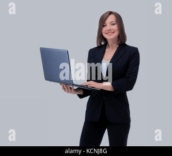 Schöne junge geschäftsfrau im Anzug hält Laptop in der Hand und lächelte, mit Blick auf die Kamera, auf weißem Hintergrund Stockfoto