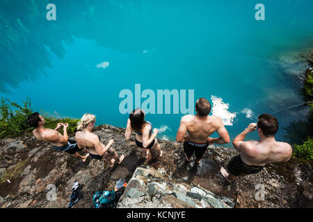 Freunde bereiten sich darauf vor, in das tourquise Wasser des Century Sam Sees im Strathcona Park einzutauchen. Vancouver Island, British Columbia, Kanada. Stockfoto