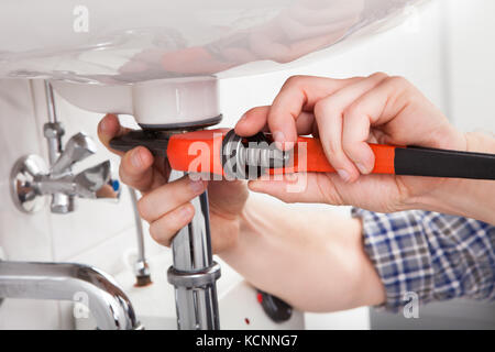 Portrait der männlichen Klempner zur Festsetzung ein Waschbecken im Badezimmer Stockfoto