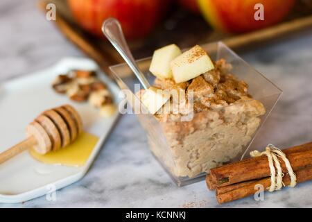 Haferflocken porridge Snack mit frischen Äpfeln, Zimt, Nüssen und Honig auf Marmor Oberfläche Stockfoto