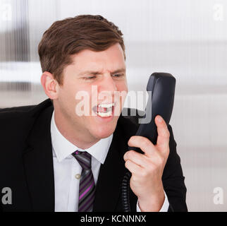 Portrait von Angry Geschäftsmann schreien am Telefon im Büro Stockfoto