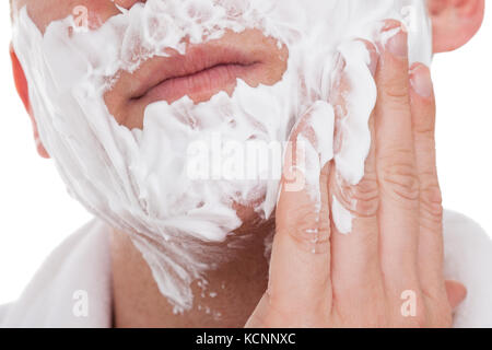 Glücklich Jüngling Auftragen von Rasierschaum, Isolated On White Background Stockfoto