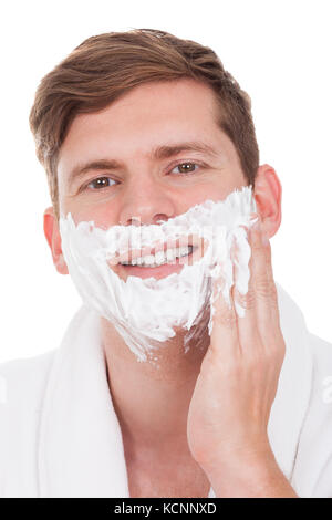 Glücklich Jüngling Auftragen von Rasierschaum, Isolated On White Background Stockfoto