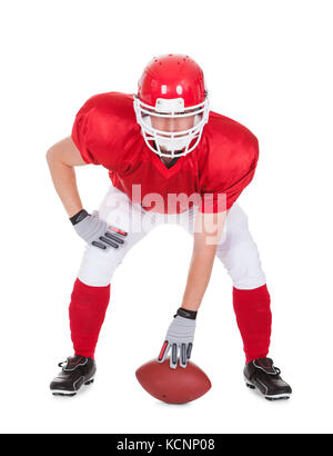 US-amerikanischer American-Football-Spieler mit Rugby In Pose Over White Background Stockfoto