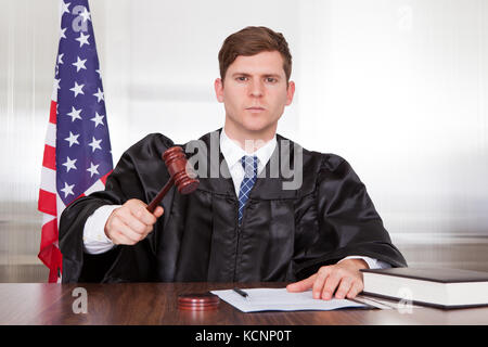 Männlich-Richter mit dem Hammer und Buch im Gerichtssaal Stockfoto