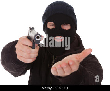 Einbrecher mit Maske, die Waffe in Richtung Kamera Stockfoto