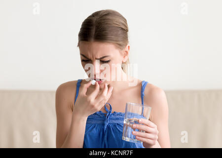 Kranke junge Frau mit Pille Glas Wasser zu Hause besorgt, jugendlich fühlt sich krank, Medizin, deprimiert Mädchen über antidepressive Pille zu nehmen, entstehen Stockfoto