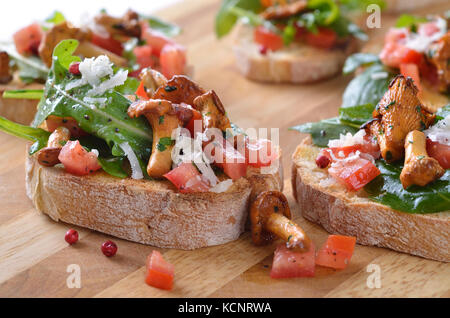 Leckere Häppchen mit Ruccola, Tomaten, Salat und gebratene Pfifferlinge Stockfoto