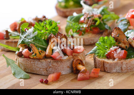 Leckere Häppchen mit Ruccola, Tomaten, Salat und gebratene Pfifferlinge Stockfoto