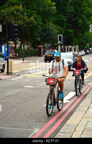 Radfahrer mit Smartphone während Reiten in London, Großbritannien Stockfoto