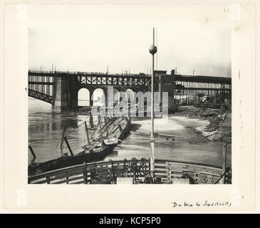 Dieses Foto zeigt das östliche Ende der EADS-Brücke in St. Louis nach dem Tornado im Mai 1896 und erfasst die Schäden an der Brückenkonstruktion, die durch den Sturm verursacht wurden. Das Bild unterstreicht die Bedeutung der Brücke als wichtiger Infrastrukturbestandteil der Stadt. Stockfoto