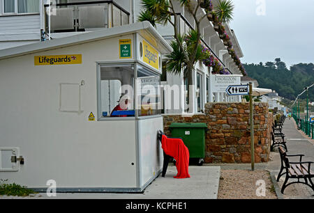 St Brelade's Bay - Jersey - Kanal Inseln - Rettungsschwimmer an der Küste Bahnhof - Leibwächter - langweilig - keine Aktion - einsame Promenade - rotes Tuch auf einen Stuhl Stockfoto