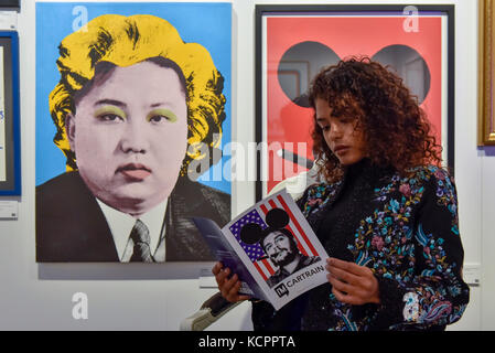 London, Großbritannien. 6. Okt 2017. Eine Frau sitzt neben 'Kim Jong-Un', 2016, von Cartrain an der Moniker Art Fair, dem weltweit größten Urban Art Fair, die in der Alten Truman Brauerei in East London vom 5. bis 8. Oktober 2017. Die Messe vereint der weltweit einflussreichsten Neu - Moderne und urbane Kunst Galerien internationale Kunstwerke zum Londoner zu zeigen. Credit: Stephen Chung/Alamy leben Nachrichten Stockfoto