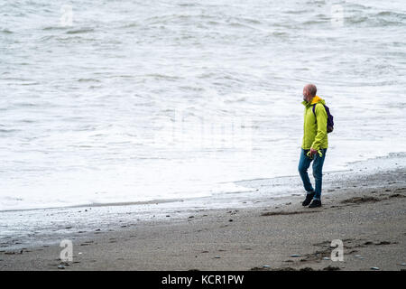 Aberystwyth Wales UK, Samstag, den 7. Oktober 2017 UK Wetter A ma nwatching the Wellen, während er entlang des Strandes an einem bewölkten und luftigen Herbstnachmittag in Aberystwyth Wales spaziert Foto: keith morris/Alamy Live News Stockfoto