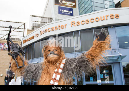 DONCASTER, South Yorkshire, UK-Star Wars Figuren und Cosplayer versammeln sich außerhalb Doncaster Racecourse für den ersten Fall der Typ an diesem Schauplatz. Mitglieder des britischen Sentinal Squad begrüßen cosplaying Gäste und gekleidet in Charaktere aus dem Star Wars Franchise einschließlich Darth Vader und Sturmtruppen. Stockfoto