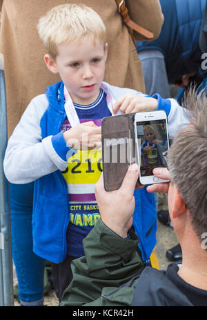 Bournemouth, Dorset, Großbritannien. 7. Okt 2017. Der erste Tag der Bournemouth Marathon Festival erhält unterwegs mit dem Kinder- Rennen - Kinder, Kilometer, Junior 1,5k, 2k und 5k. Ein Foto der jungen Knaben mit schlichten Medaille. Credit: Carolyn Jenkins/Alamy leben Nachrichten Stockfoto