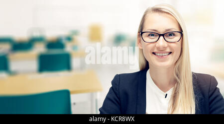 Junge lächelnde Lehrerin im Klassenzimmer Stockfoto