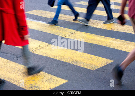 Blurry Beine junger Menschen zu Fuß auf Zebrastreifen auf die Straße Stockfoto