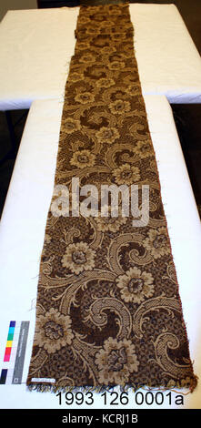 Ein detailliertes Bild eines Teppichabschnitts, das das komplizierte Design und die Textilindustrie zeigt. Der Schwerpunkt liegt auf dem Muster, Material und den Farben, die bei der Herstellung des Teppichs verwendet wurden, und spiegelt die Kunstfertigkeit wider, die bei der Herstellung des Teppichs verwendet wurde. Stockfoto