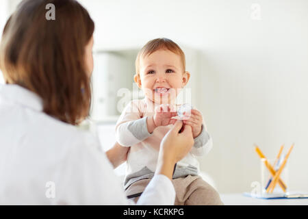 Gerne Arzt oder Kinderarzt mit Baby an der Klinik Stockfoto