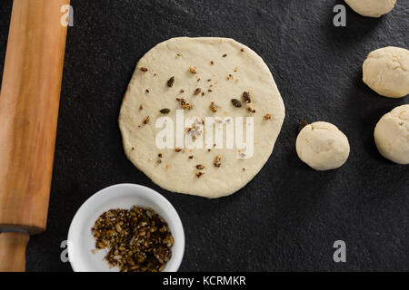 Über dem Kopf Blick auf die trockenen Früchte über abgeflacht Teig hinzugefügt Stockfoto