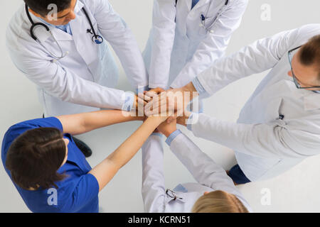 Gruppe von Ärzten mit Hände zusammen am Krankenhaus Stockfoto