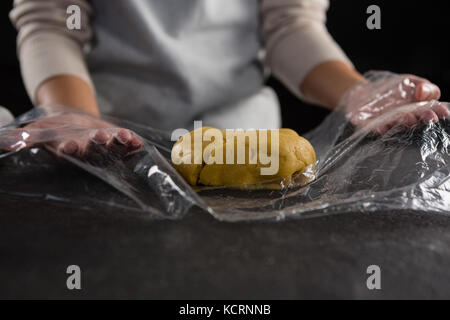 Den mittleren Abschnitt der Frau Verpackung Teig in einer Plastikverpackung Stockfoto