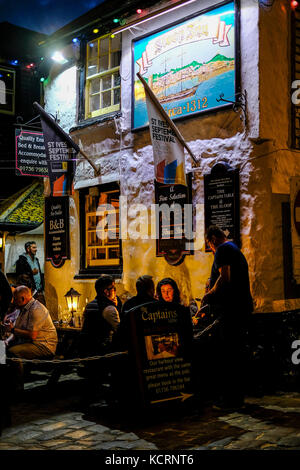 Die Menschen sitzen draußen auf der Sloop Inn St Ives an einem milden Abend Ende September Stockfoto