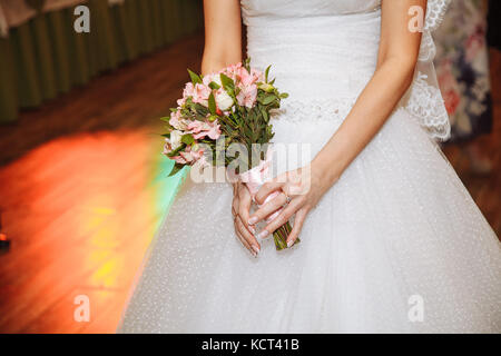 Schöne Braut im Brautkleid mit wedding bouquet, rosa Blumen und Grün. Stockfoto