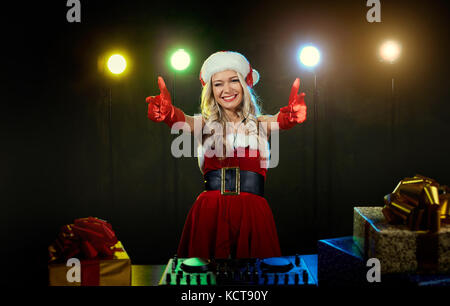 Dj Mädchen in einer Weihnachtsmütze Weihnachten. Stockfoto