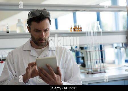 Aufmerksame Student mit digitalen Tablette im Labor Stockfoto